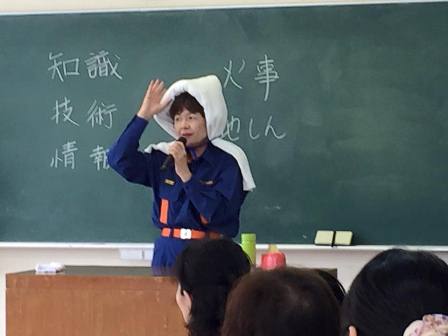 バスタオルを使った防災ずきんについて説明する寺本さん