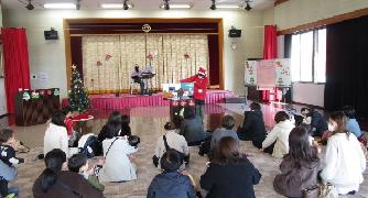 あそびの会で紙芝居を見るこどもたち