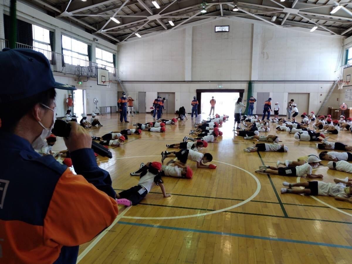 SDR(ストップ ドロップアンドロール)服に火が付いた時の消火の仕方を学ぶ様子