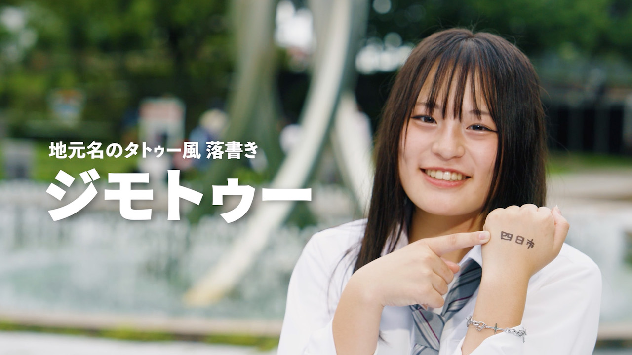 1.地元名のタトゥー風落書きジモトゥーを指さす女性