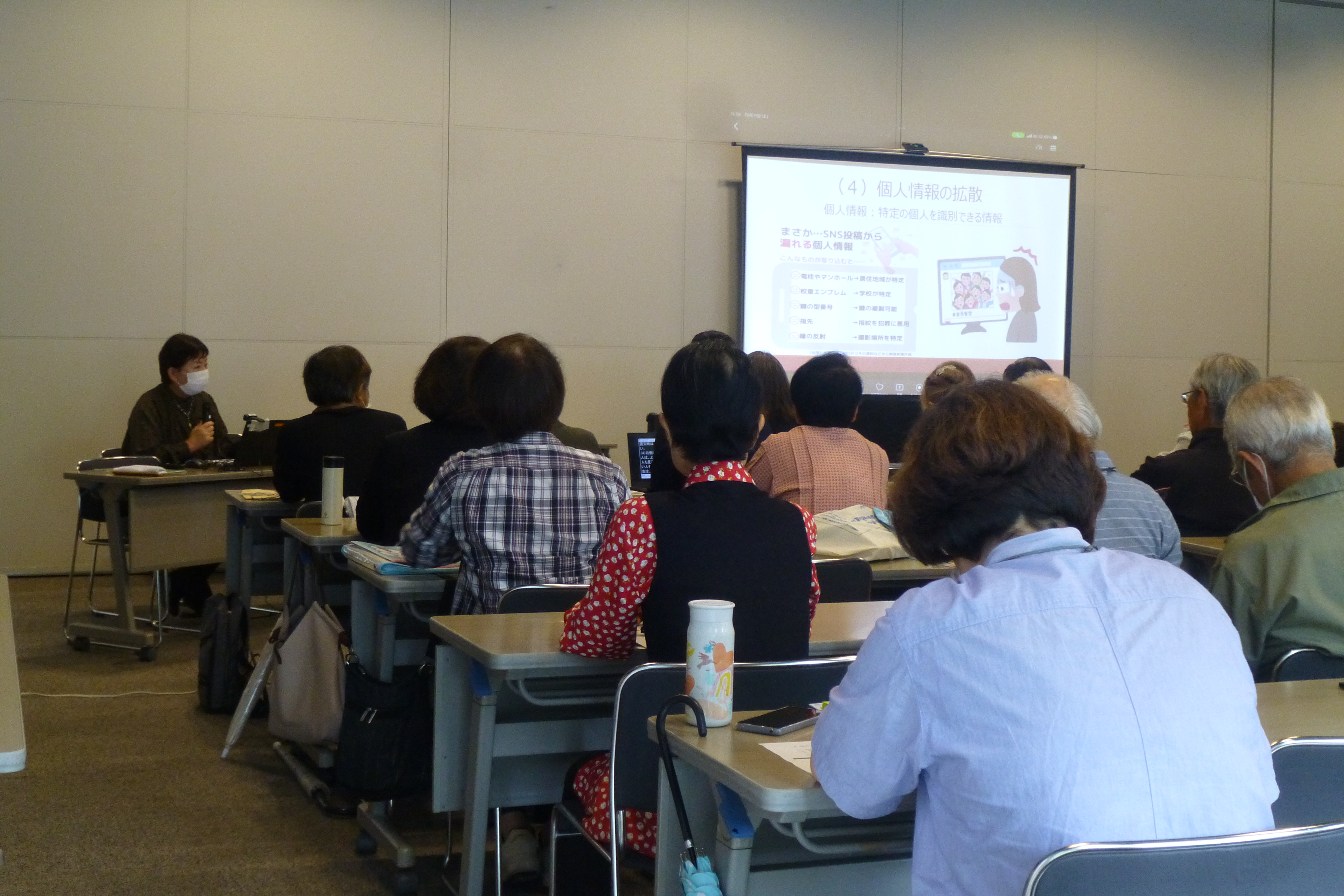 プロジェクターで投映された資料の説明を聞く参加者