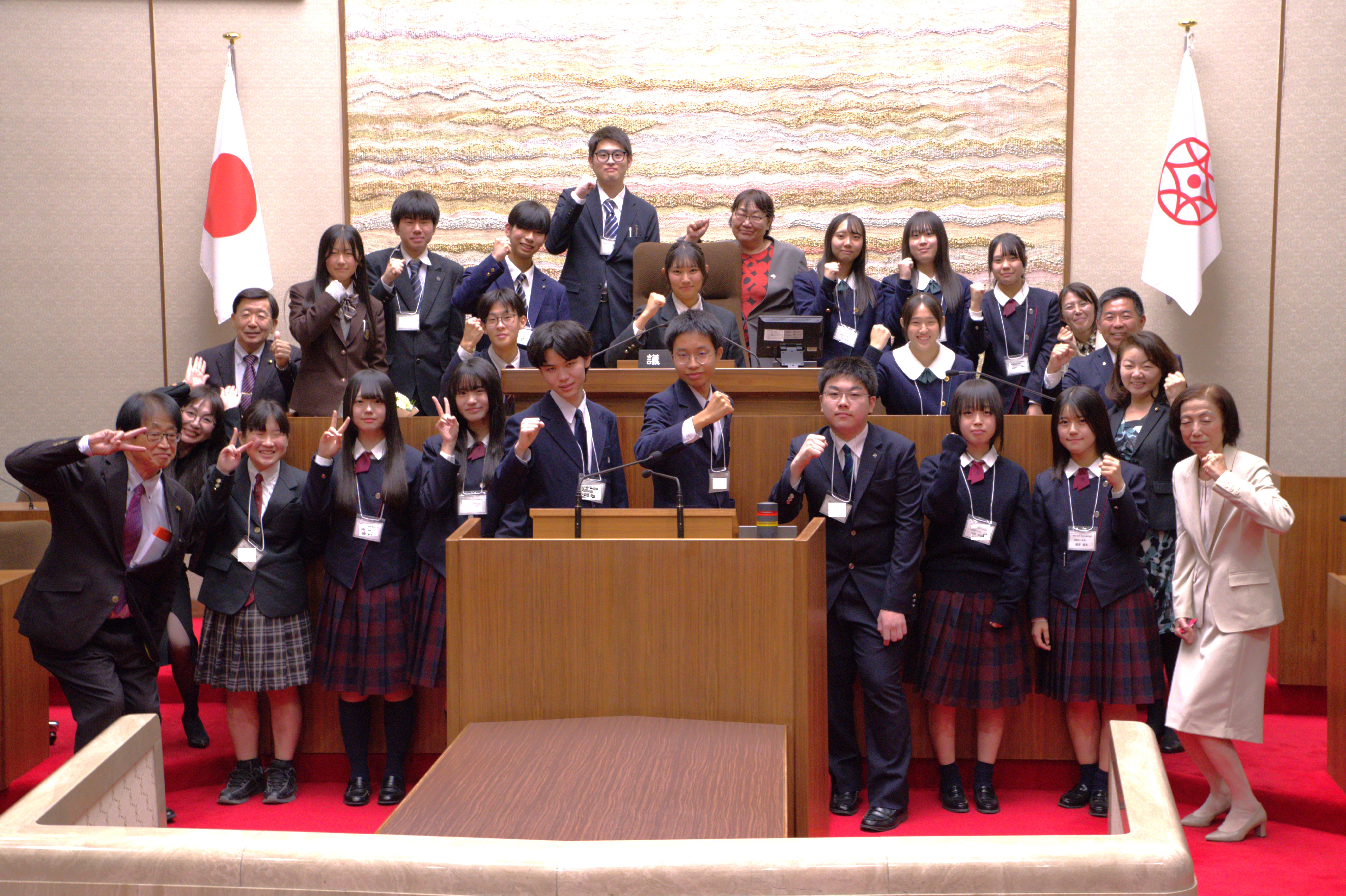 議長席を中心に集まる高校生議員と市議会議員による集合写真