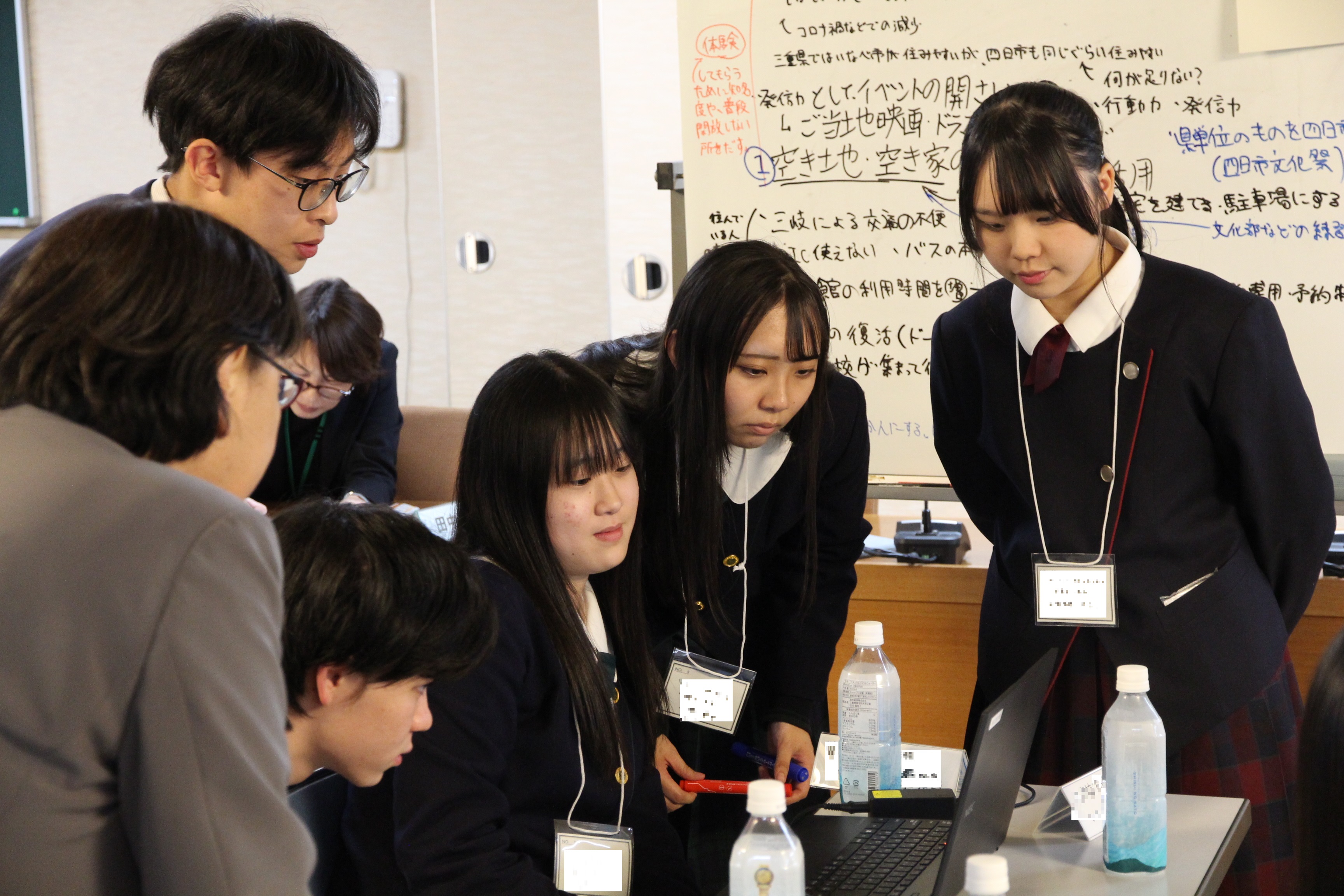 パソコンの前にあつまり、内容を確認する高校生議員