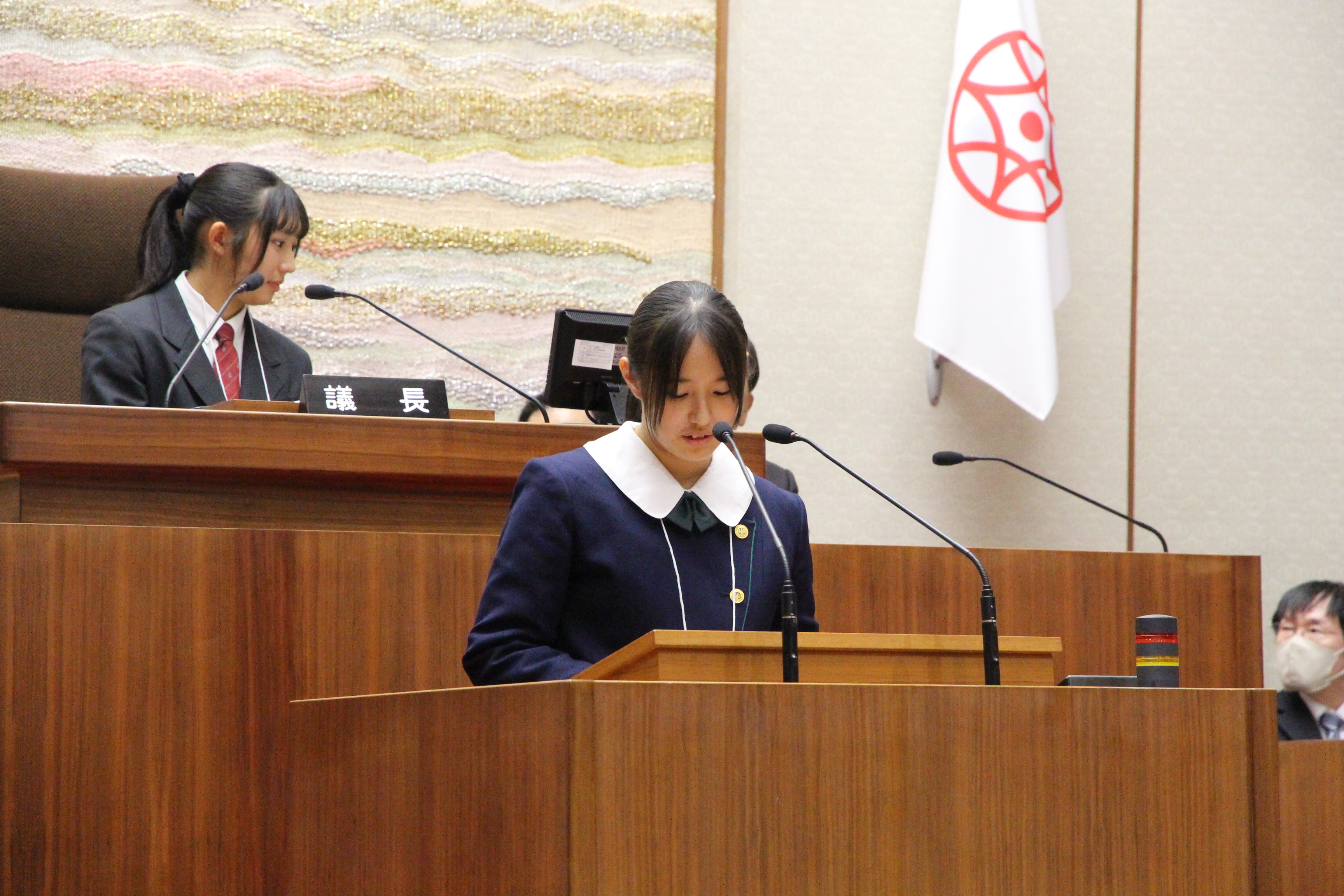 演台に立ちAグループの報告をする高校生議員