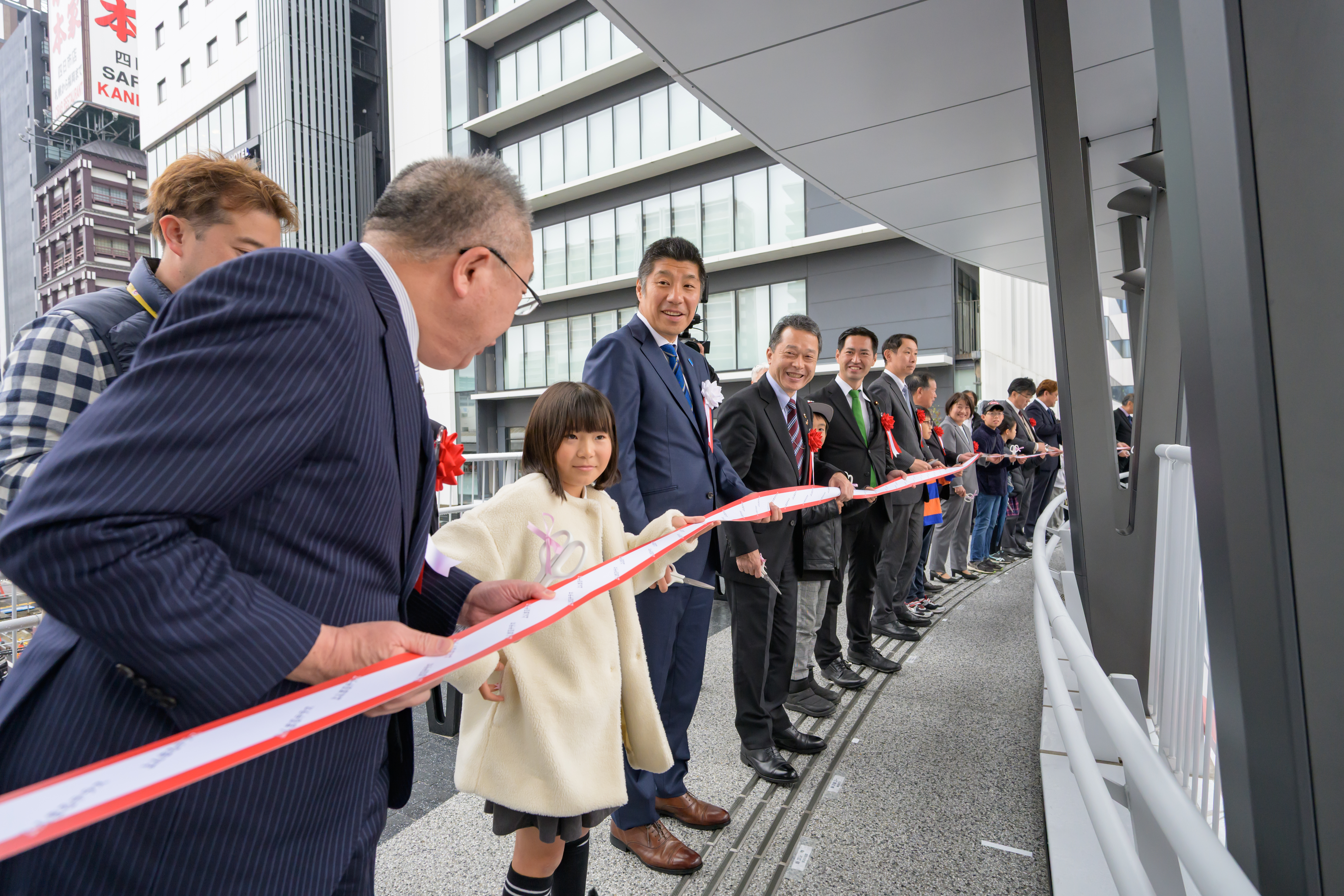 円になって、テープカットをする参加者